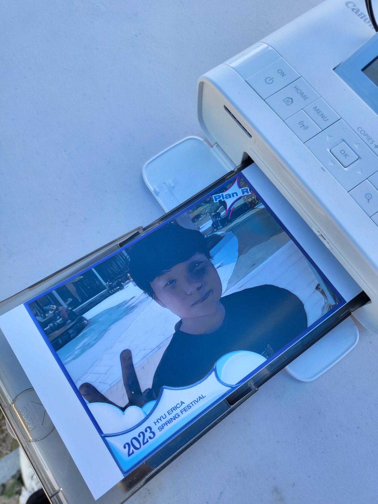 A photo printer producing a stylized photo at the festival booth