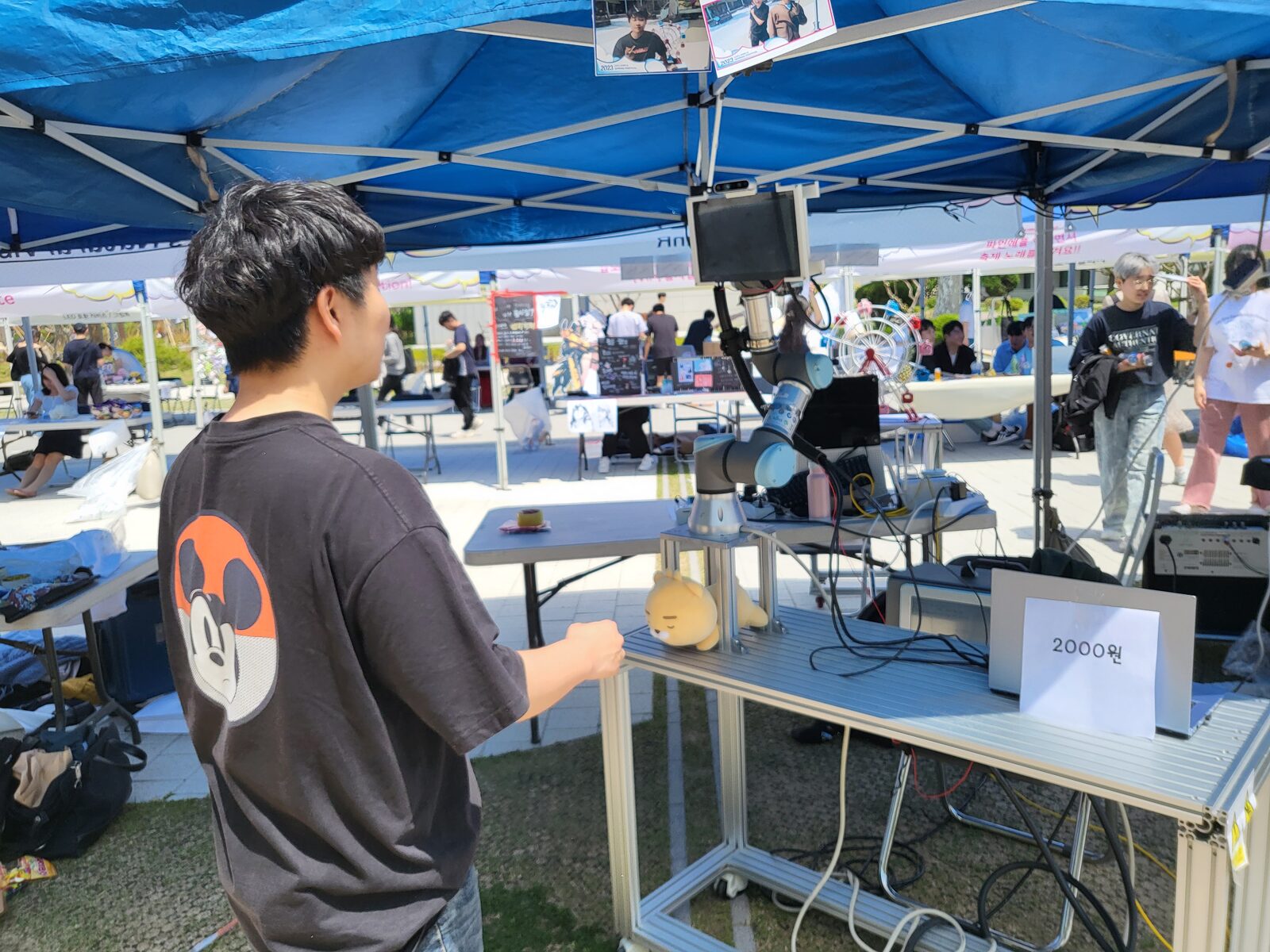 Snapbot autonomously photographing a festival visitor under the booth tent
